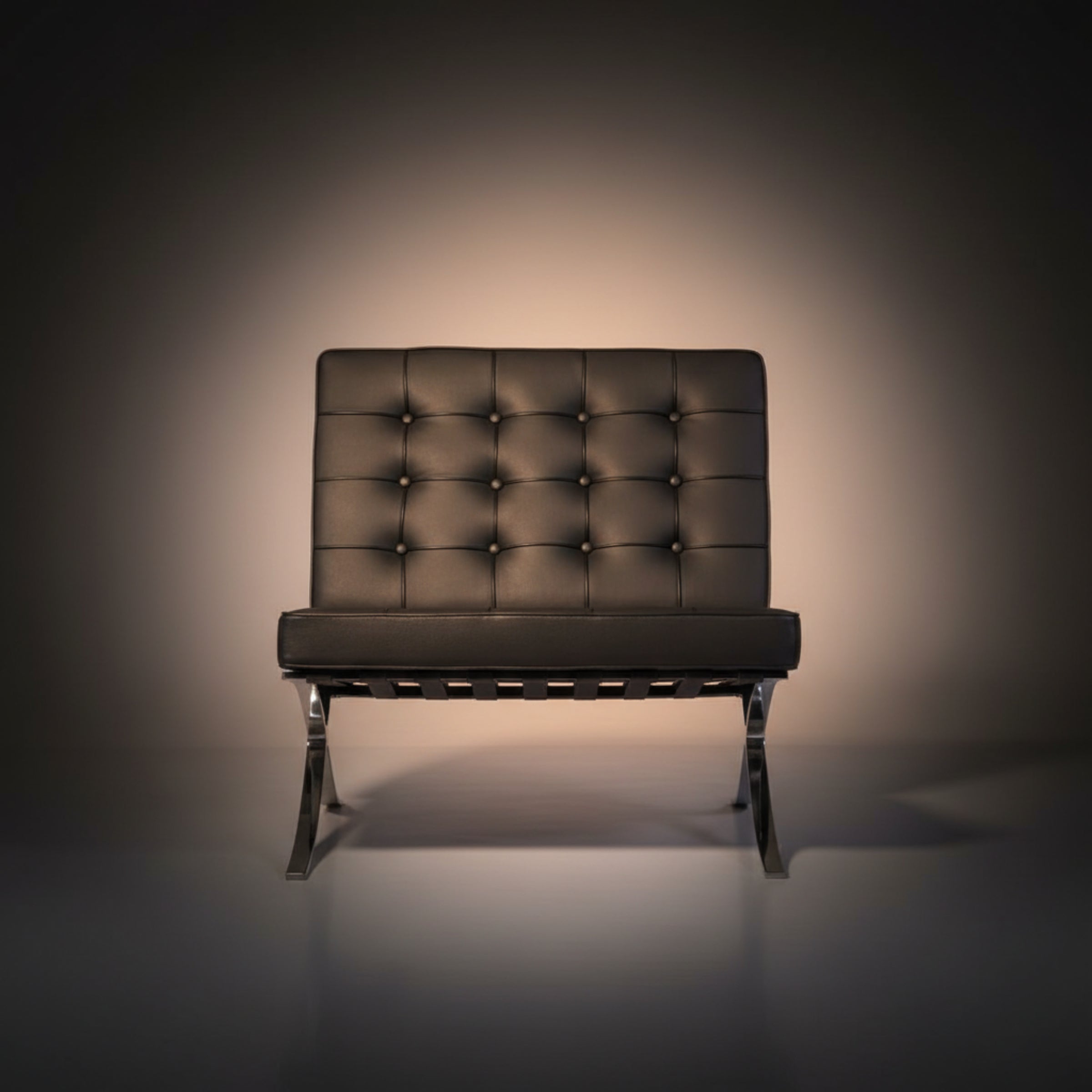 A modern armless lounge chair with a tufted dark brown leather backrest and seat, supported by a chrome metal frame.