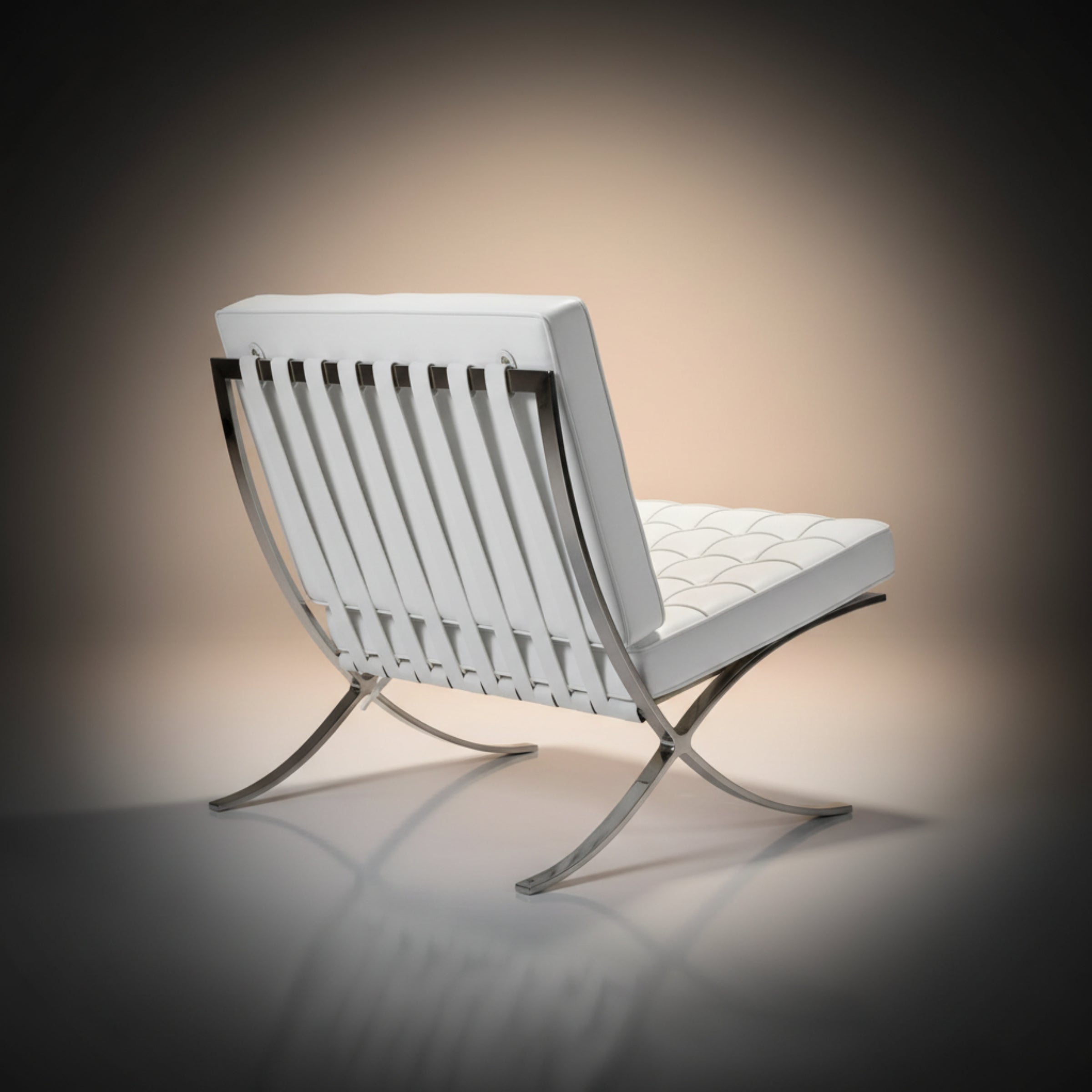 A modern white leather Barcelona lounge chair with a curved chrome metal frame, shown | Aura Furnitures