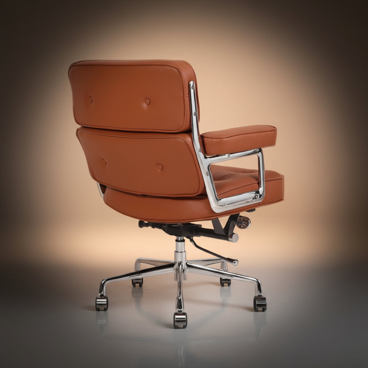 A mid-century modern office chair with a warm cognac brown leather seat and backrest, featuring a chrome-finished metal frame.