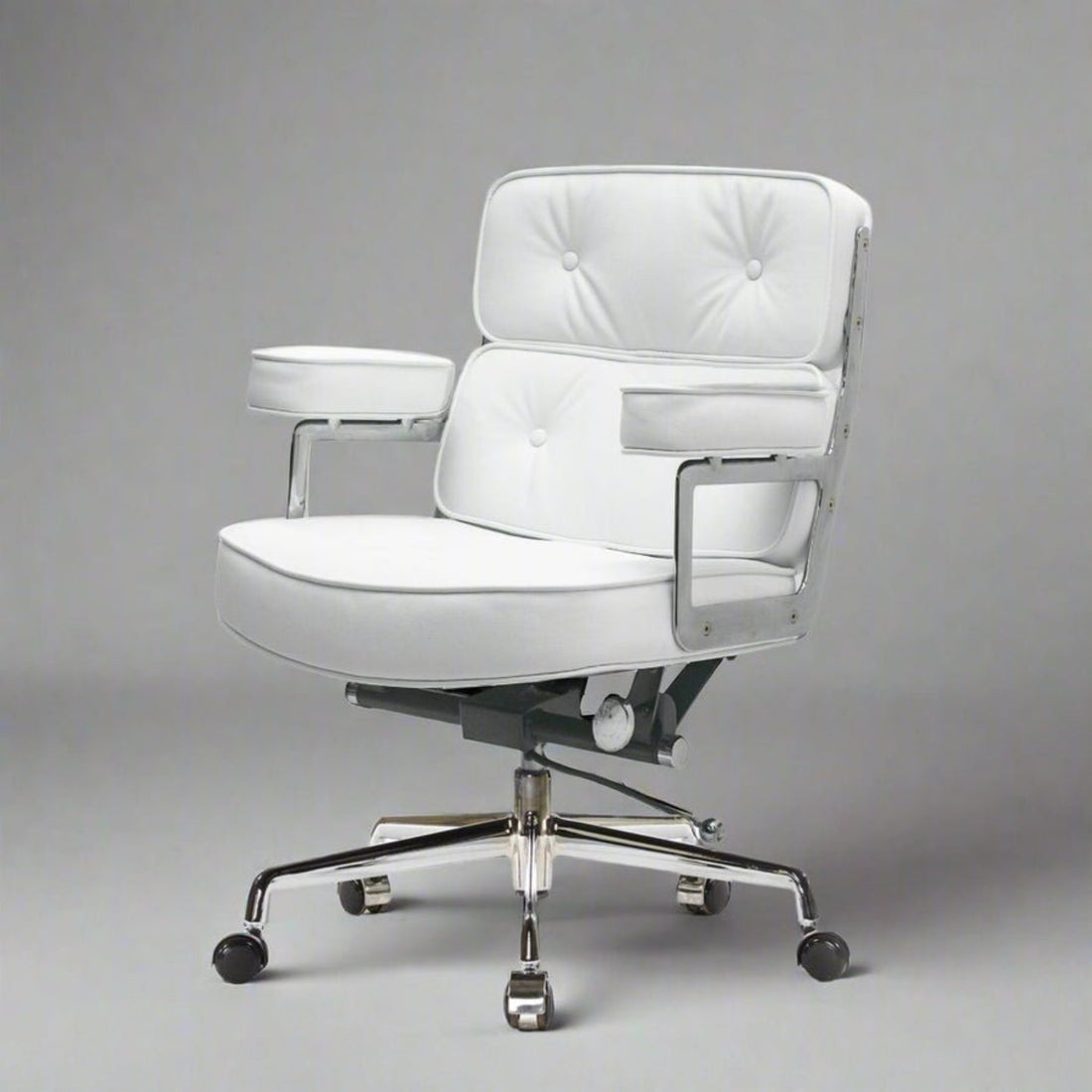 A modern white upholstered office chair with tufted back and seat cushions, chrome metal arm supports, a black gas-lift mechanism.