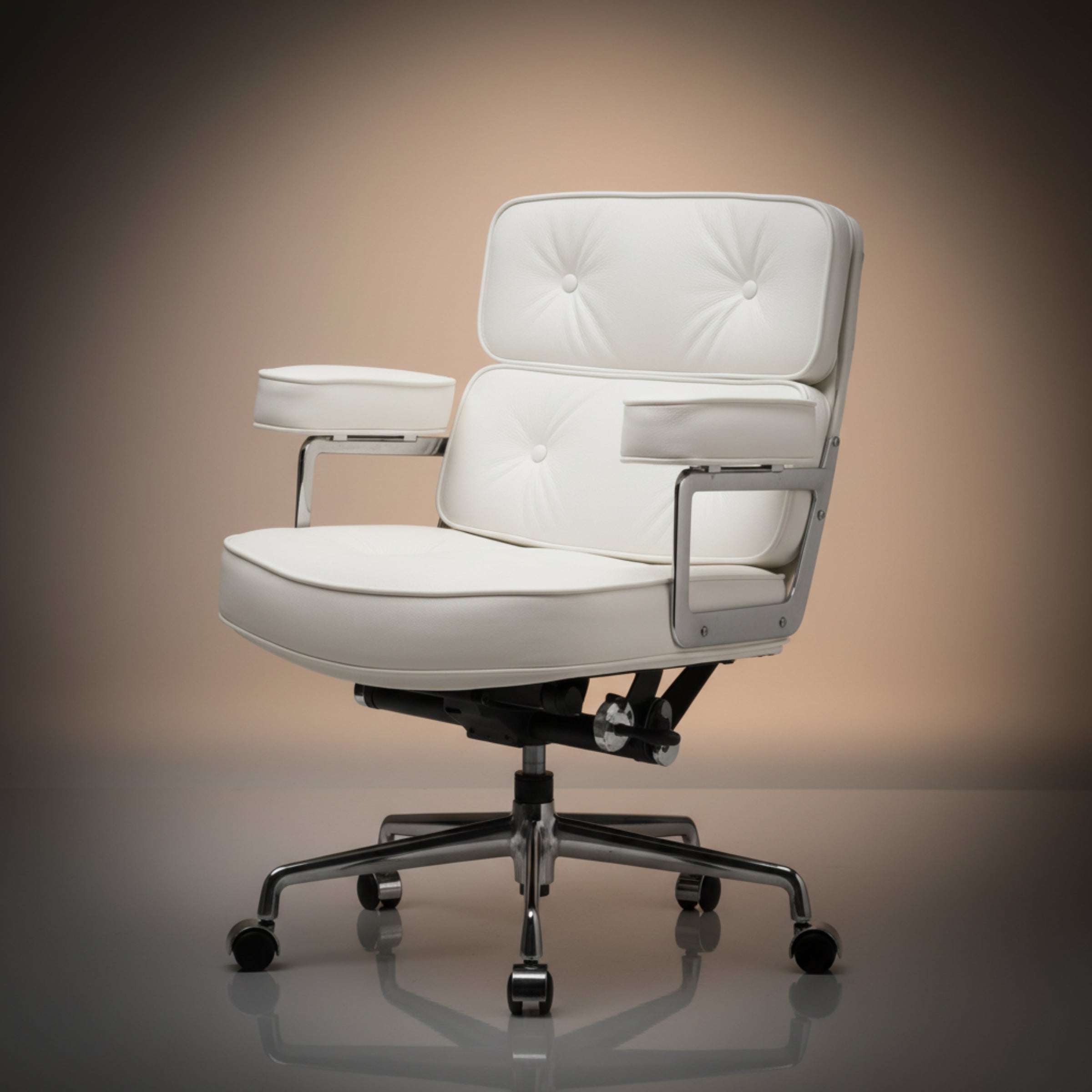 A modern white upholstered office chair with tufted backrest and armrests, mounted on a chrome five-star base with casters, shown on a reflective surface.