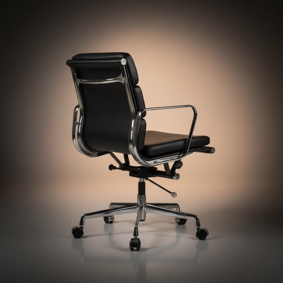A modern office chair with black leather upholstery and a polished chrome five-star base.