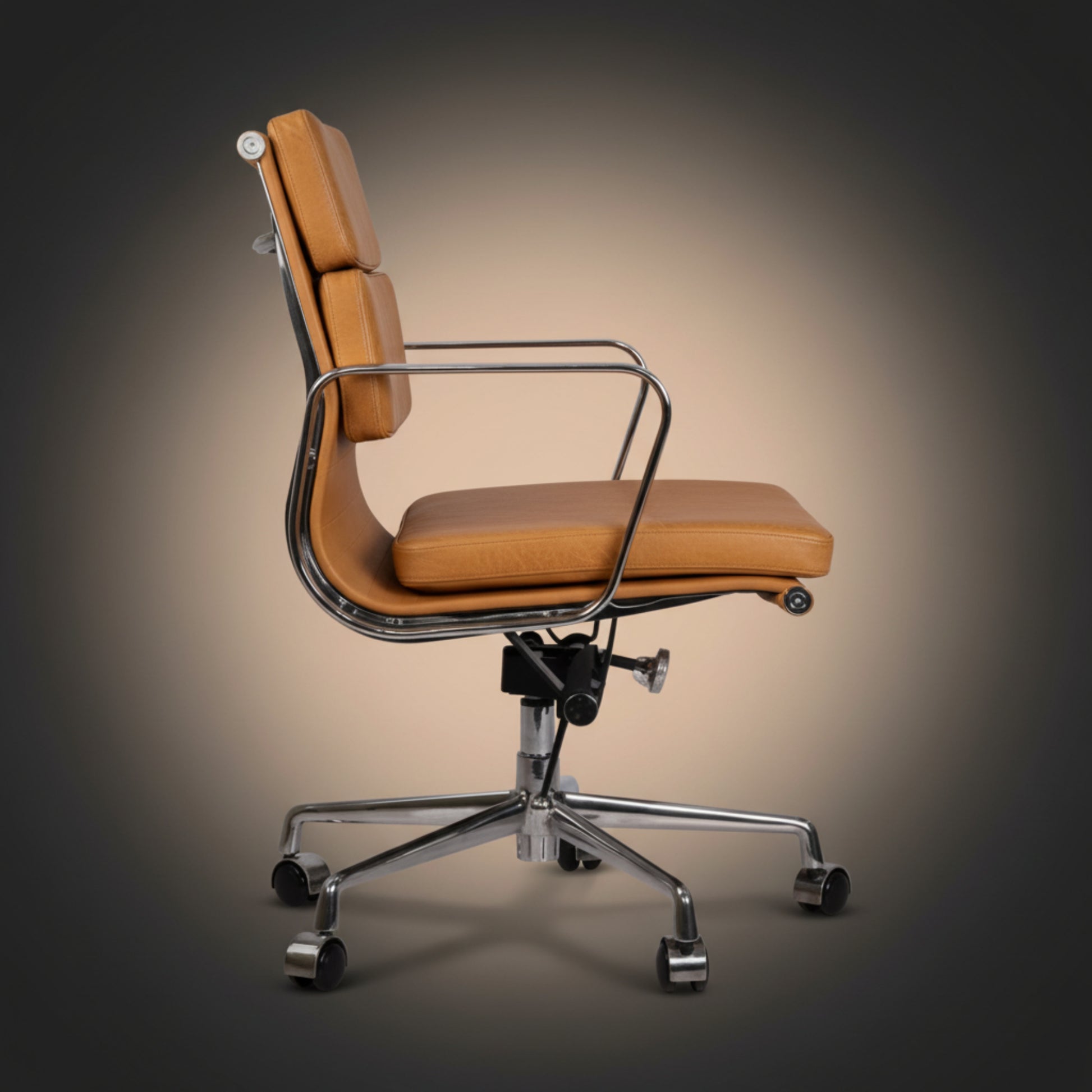 A modern high-back office chair with tan leather upholstery and a chrome metal frame, base.