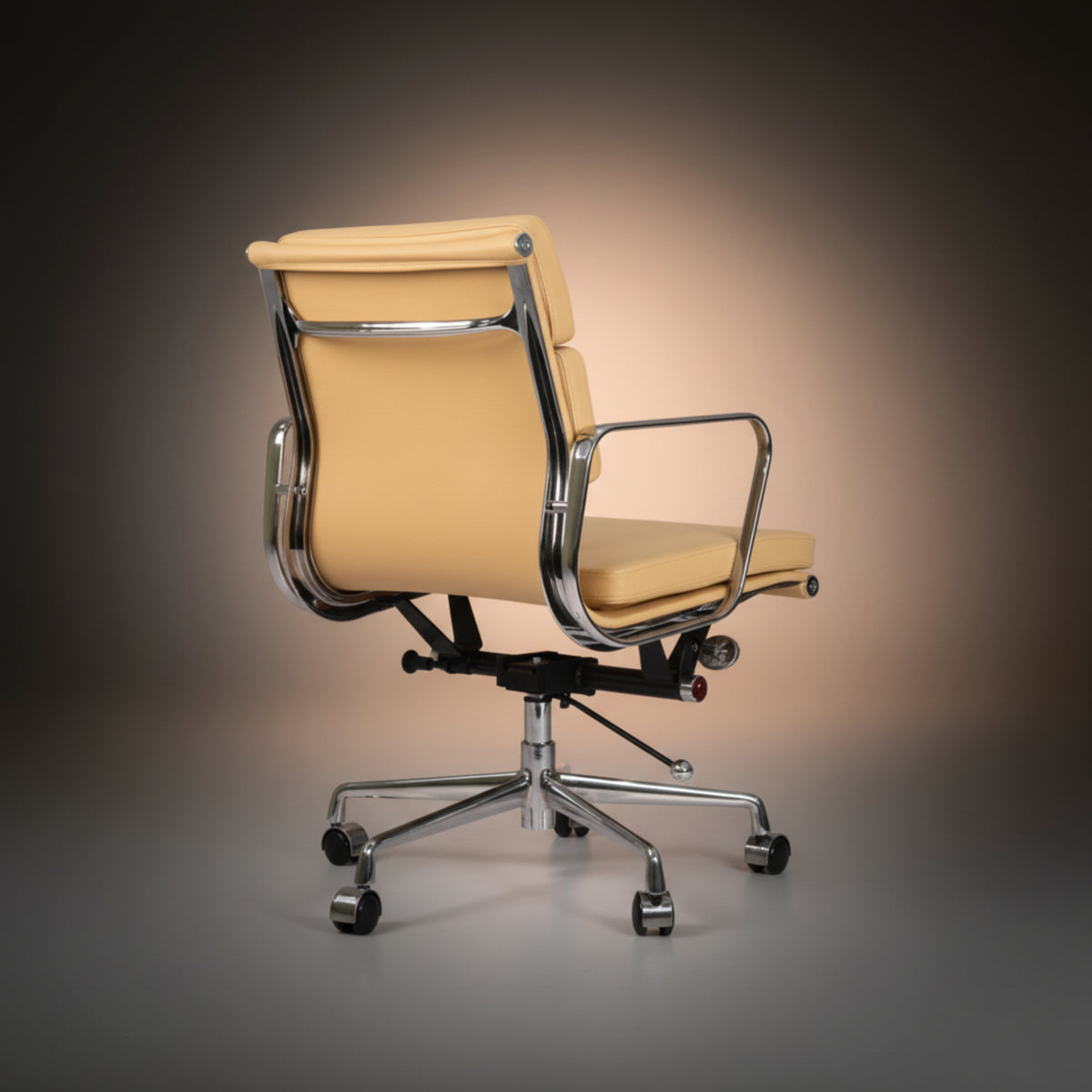 A modern office chair with a light beige leather seat and backrest, supported by a polished chrome metal frame.