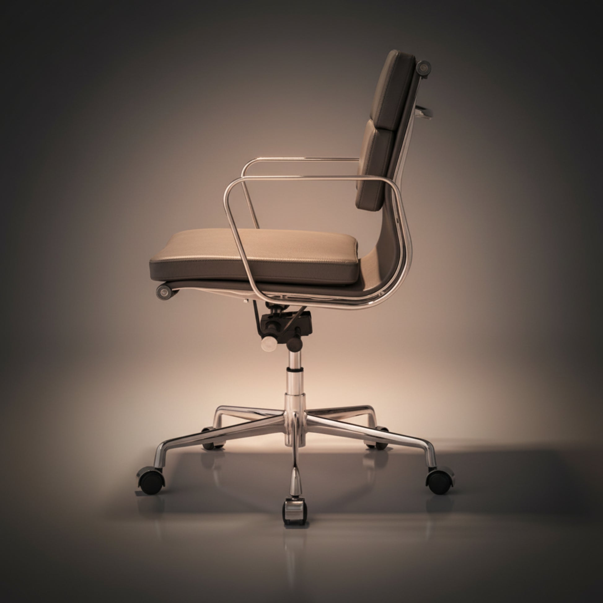 A modern office chair with a beige upholstered seat and backrest, a clear curved metal arm frame.