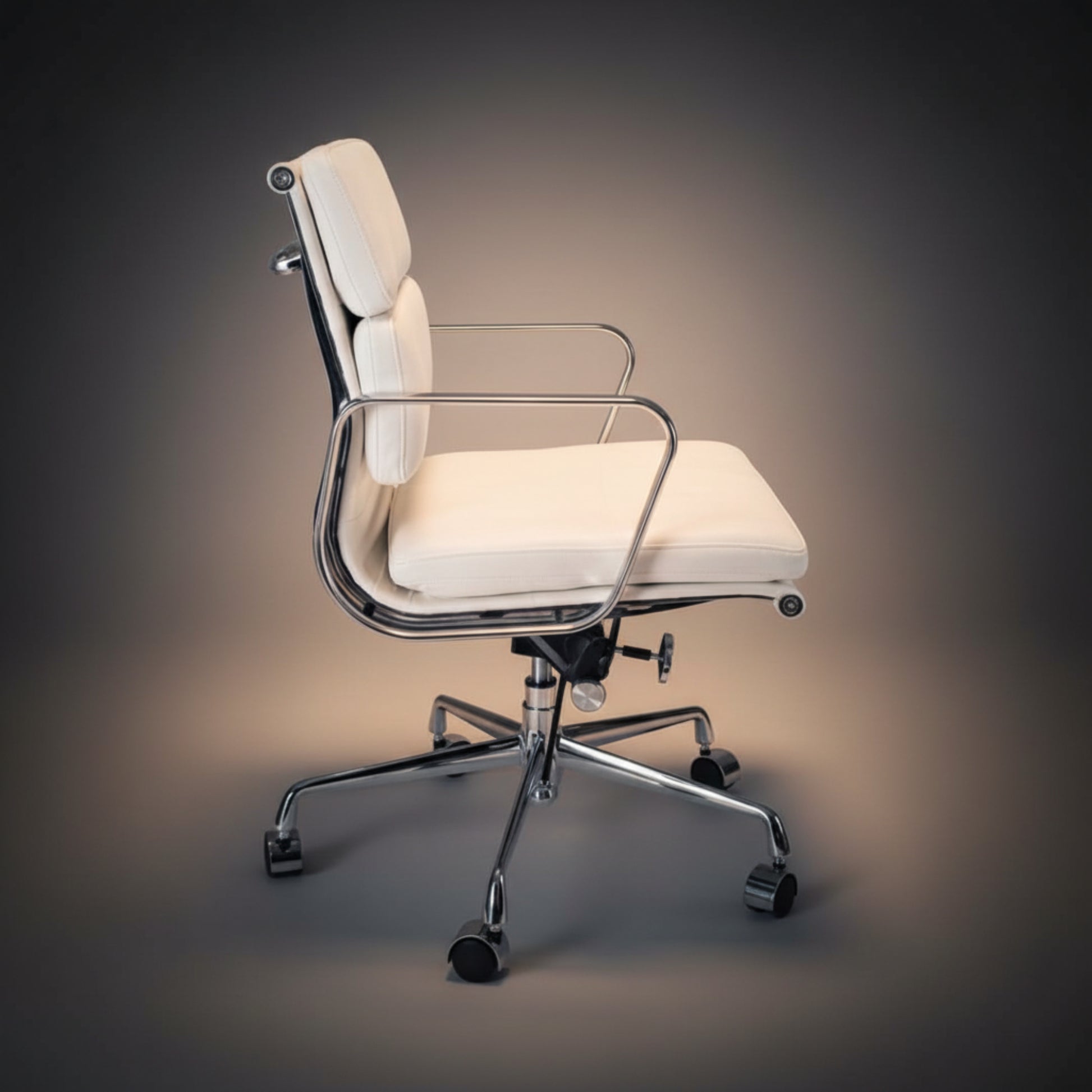 A modern office chair with cream-colored padded upholstery and a polished chrome metal frame.