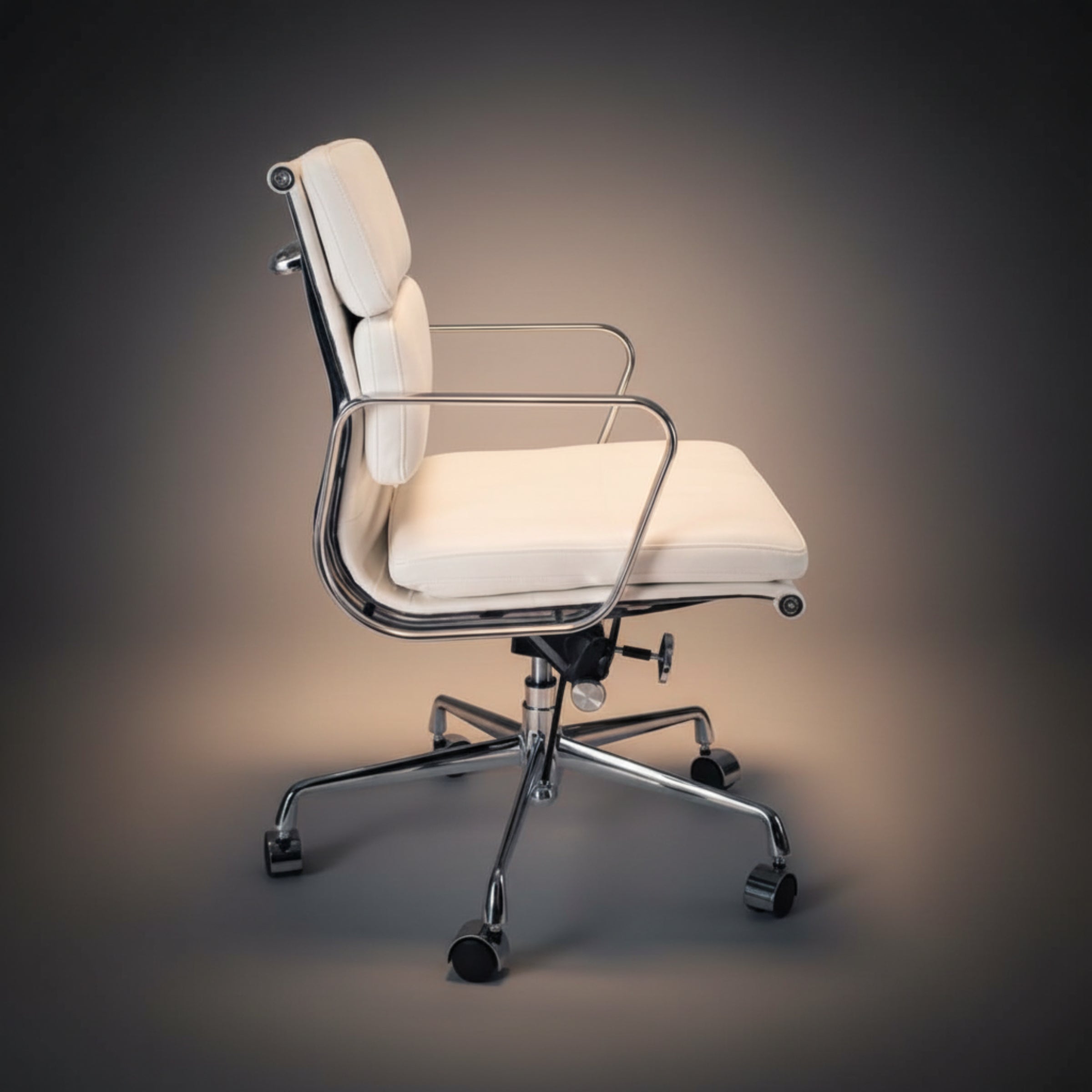 A modern office chair with cream-colored padded upholstery and a polished chrome metal frame.
