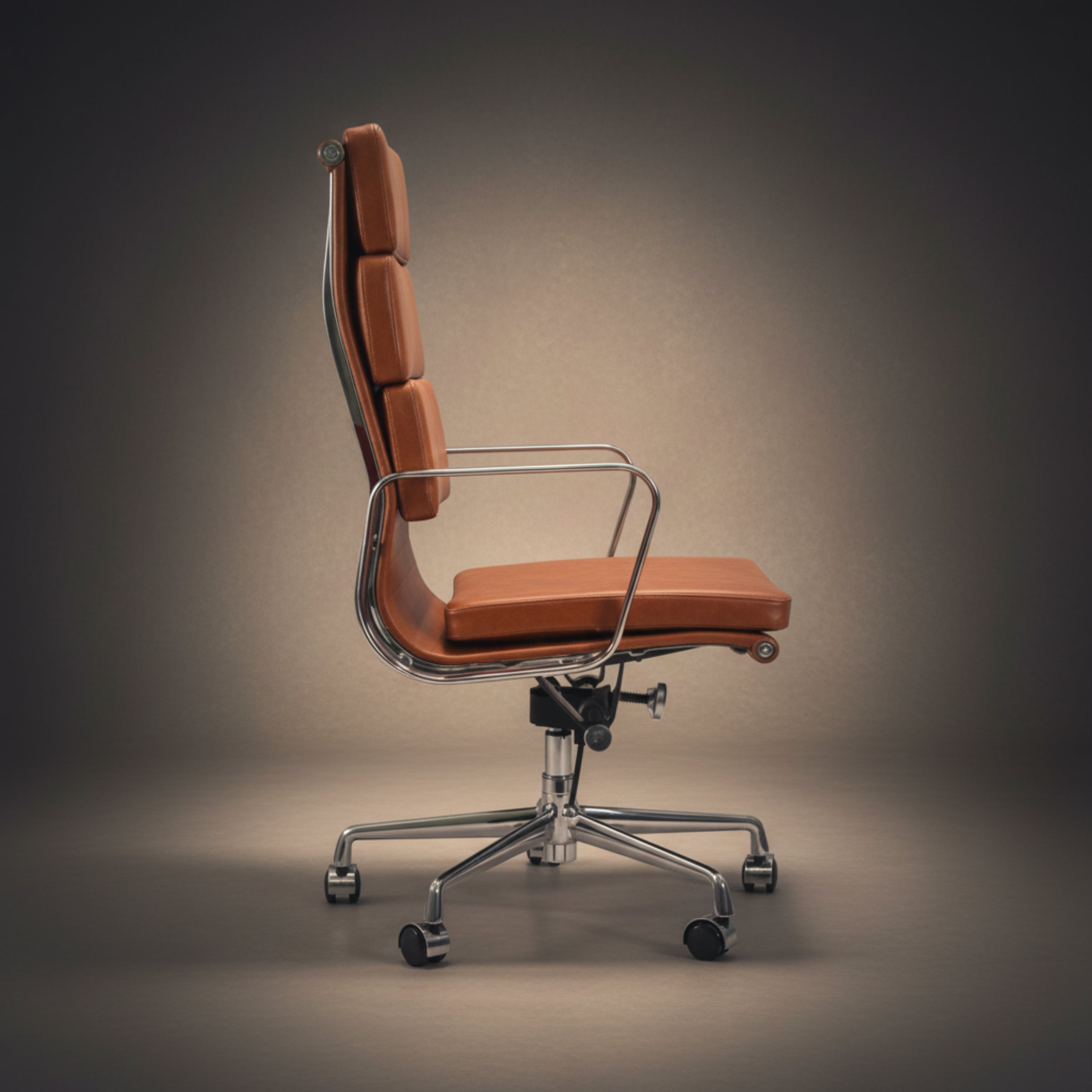 A modern high-back office chair with orange-brown leather upholstery and a chrome five-star base